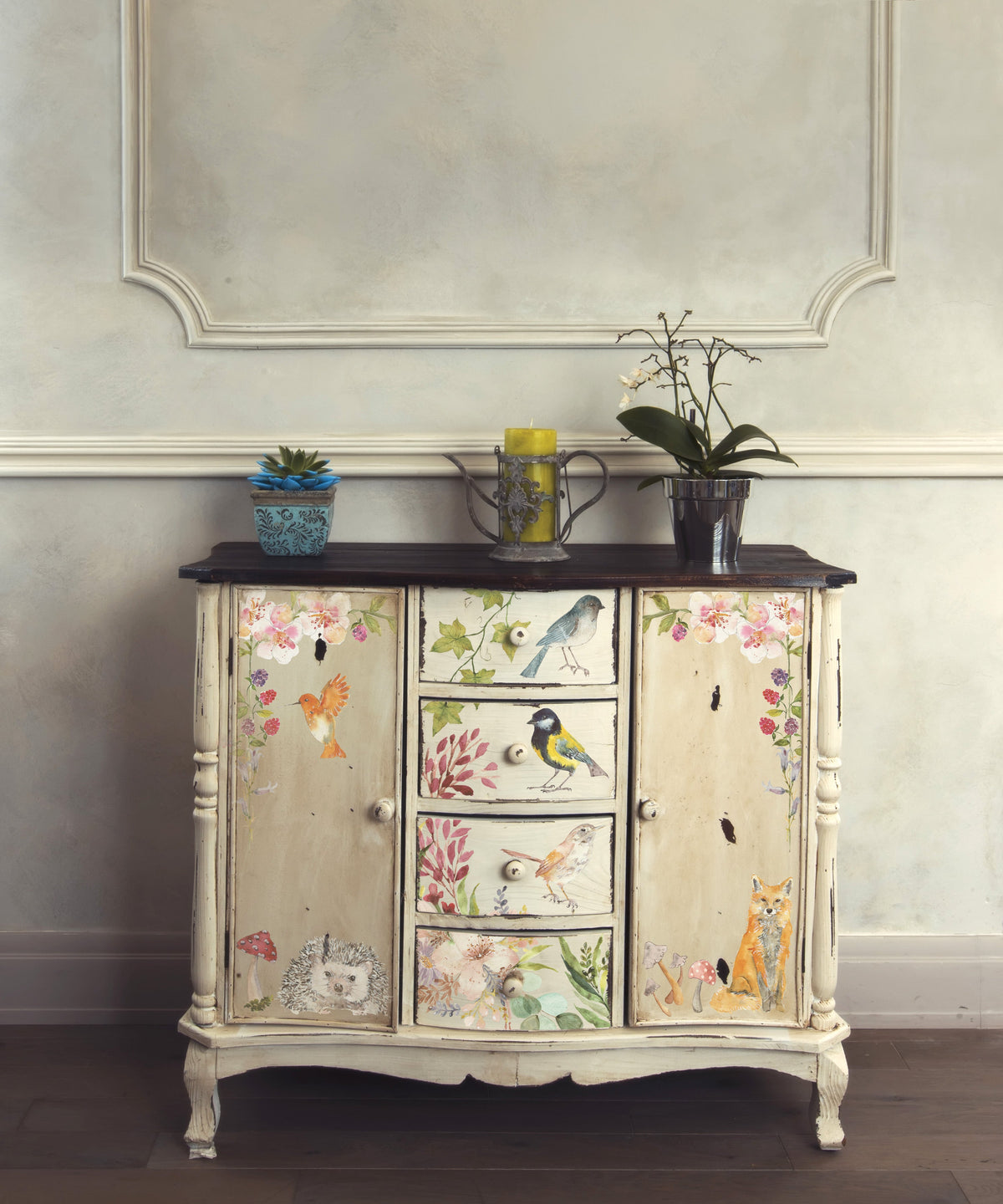 Painted cabinet with animal and nature motifs, topped with plants, candle, and I.O.D. Whispering Willow Transfer.
