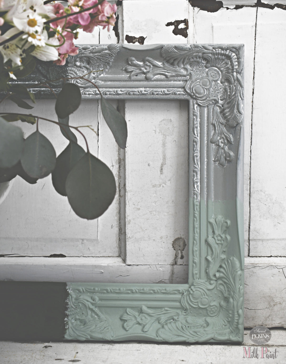 Ornate frame leaning on door finished with White Oil Wax by Old Fashioned Milk Paint, flowers placed nearby.