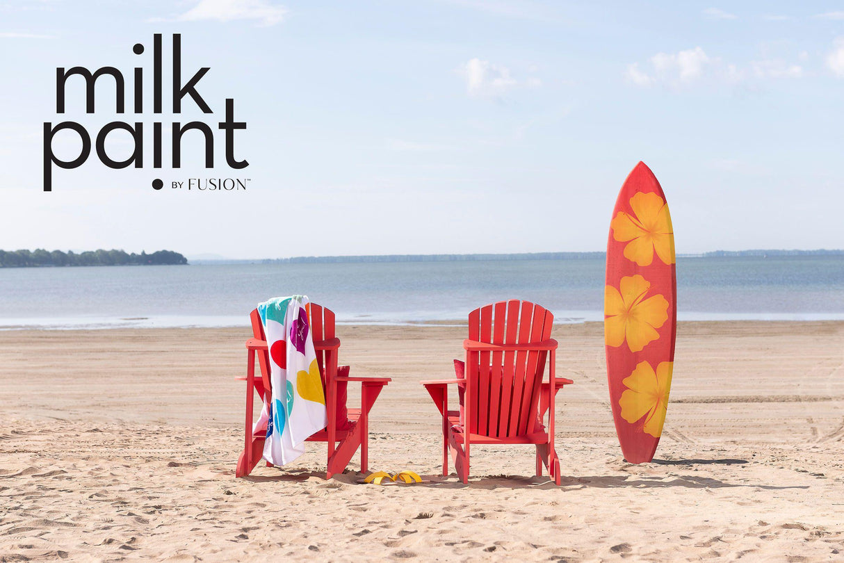 Two red chairs and a surfboard on sand; “Hawaiian Hibiscus Milk Paint by Fusion Mineral Paint” text in corner.