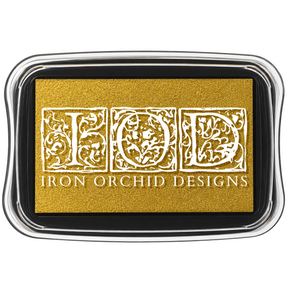 I.O.D. Metallic Ink Pad, gold shimmer, in clear case labeled Iron Orchid Designs with ornate white lettering.