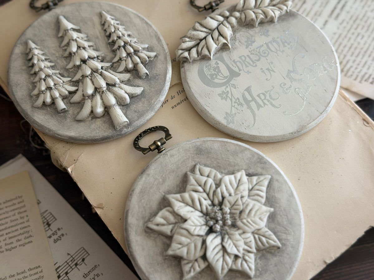 Three round Boughs of Holly ornaments by I.O.D.: two embossed, one with faded text, 2026 Limited Release.