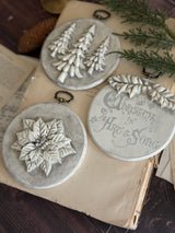 Set of 3 round ornaments featuring trees, poinsettia, and text, made with I.O.D. Boughs of Holly (2026 Limited Release) mould.