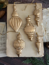 Five gold baubles crafted with the 2026 Baubles Mould by IOD displayed on a vintage book.