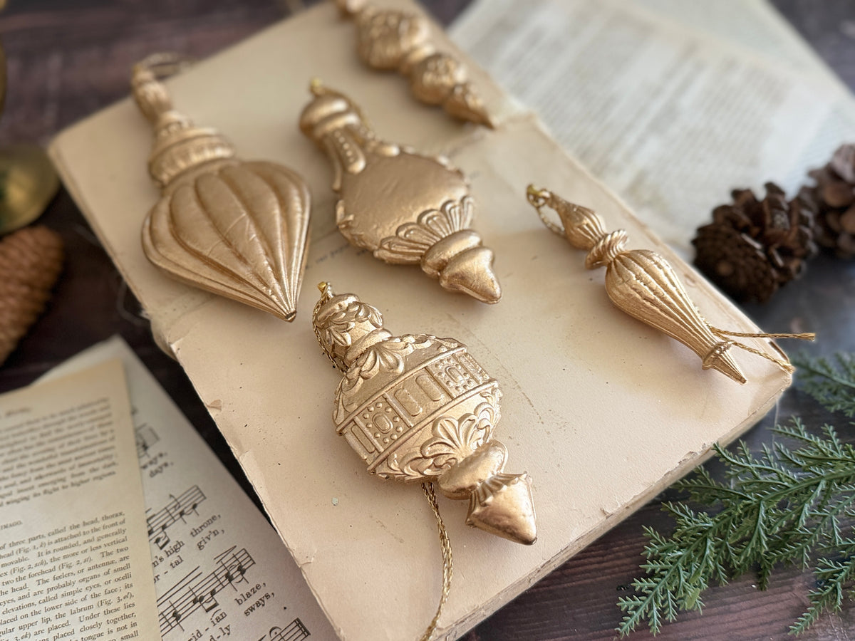 Six Baubles Mould (2026 Limited Release) by IOD ornaments arranged with sheet music, pinecones, and greenery.