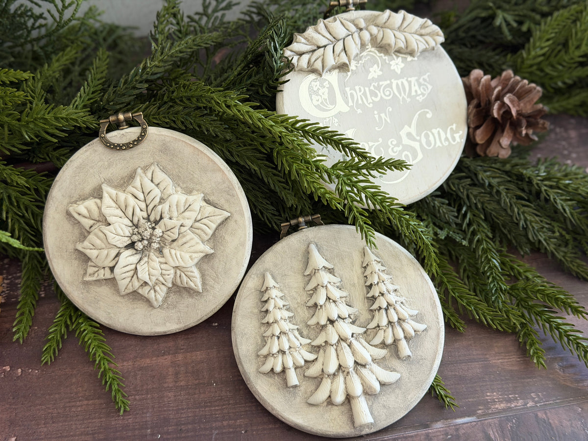Three Boughs of Holly (2026) ornaments by I.O.D., created with vintage Christmas moulds, displayed on greenery.