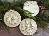 Three Boughs of Holly (2026) ornaments by I.O.D., created with vintage Christmas moulds, displayed on greenery.