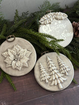 Boughs of Holly (2026) by I.O.D.; 3 round beige ornaments with vintage moulds—poinsettia, trees, festive text.