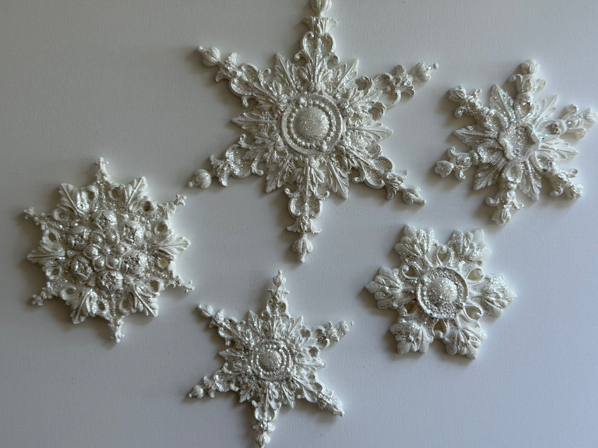 Five white I.O.D. Snowflakes Mould (2026 Limited Release) decorations displayed on a plain background.