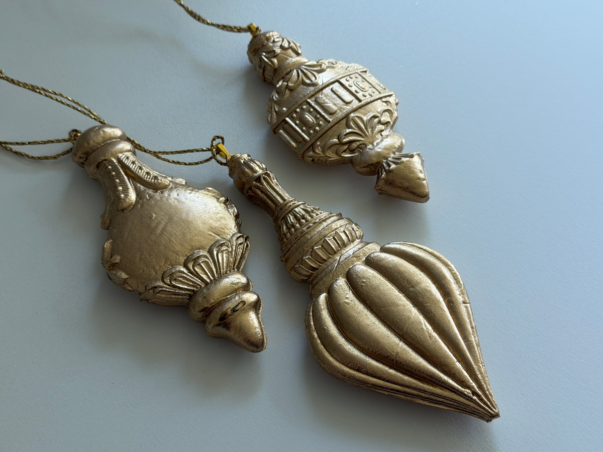 IOB 2026 Limited Release three gold Baubles Mould ornaments with intricate designs.