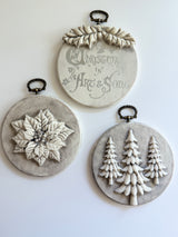 Three round plaques with raised designs from I.O.D. Boughs of Holly (2026 Limited Release), vintage Christmas style.