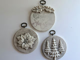 Three Boughs of Holly ornaments by I.O.D. with vintage Christmas greetings, poinsettias, and pine designs.