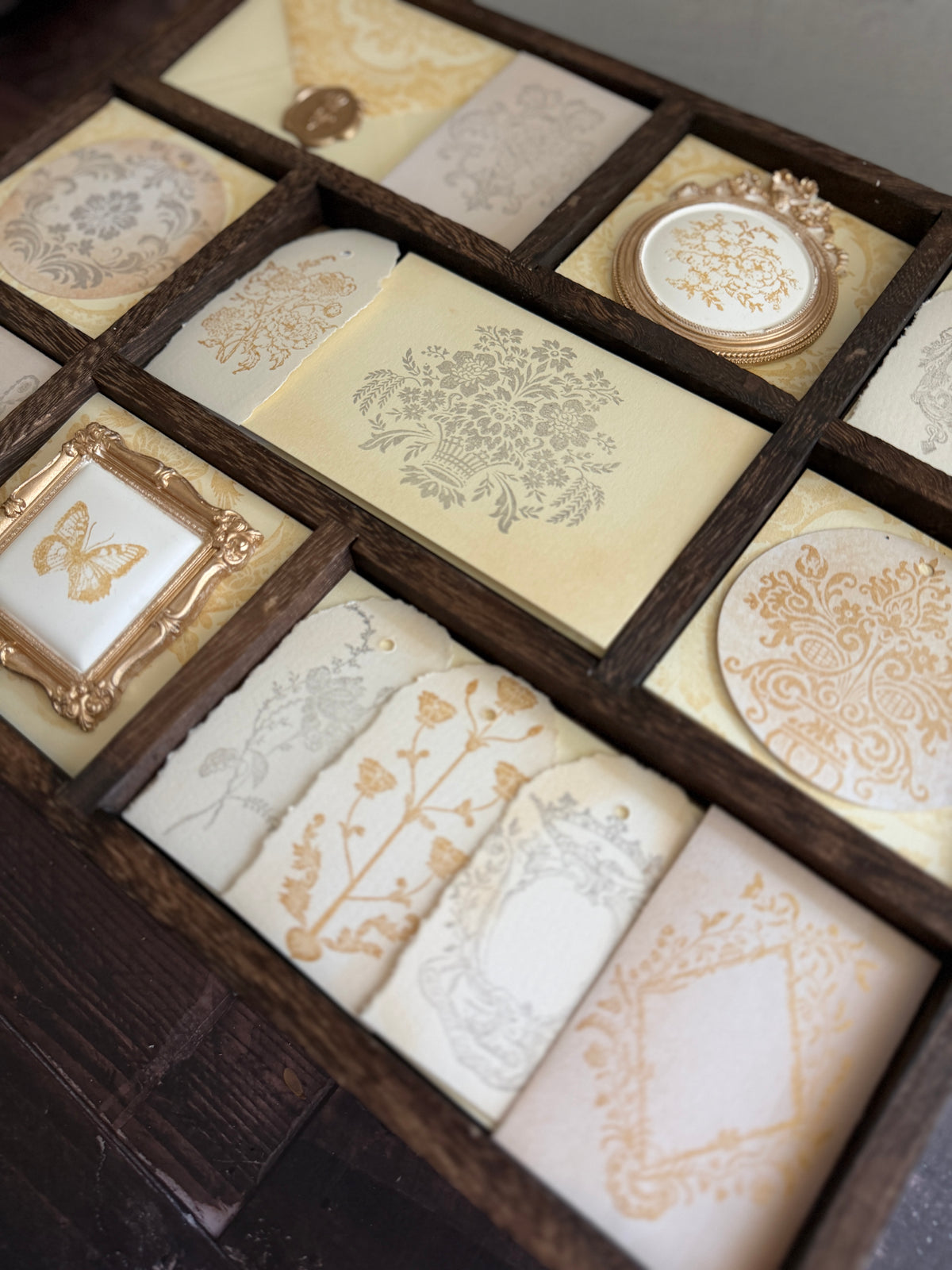 I.O.D. Metallic Ink Pads & Refills by Iron Orchid Designs in gold and silver arranged on a wooden tray.