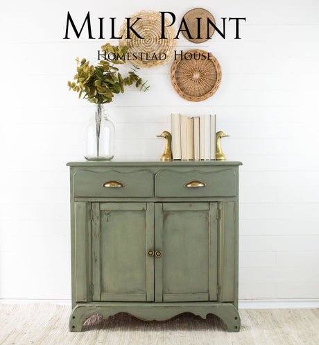 Cabinet in Homestead House Acadia Pear Milk Paint with gold duck bookends, stacked books, leafy vase, and woven accent.