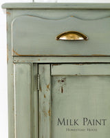 Distressed green cabinet with brass handle; Homestead House Acadia Pear Milk Paint shown bottom right.