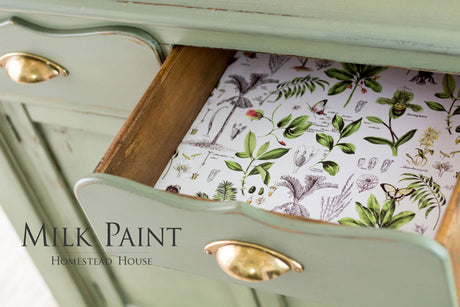 Green drawer with brass handle, floral liner; labeled Acadia Pear Milk Paint by Homestead House.