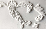 White plaster molding made with I.O.D. Acanthus Scroll Mould and air dry clay, featuring floral designs.