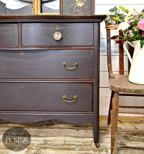 Old Fashioned Milk Paint vintage dresser in Adelaide beside a chair and a pitcher of flowers.