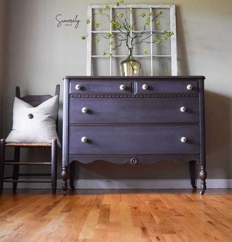 Dark dresser painted with Old Fashioned Milk Paint’s Adelaide, vase with green branches on top, next to a chair.