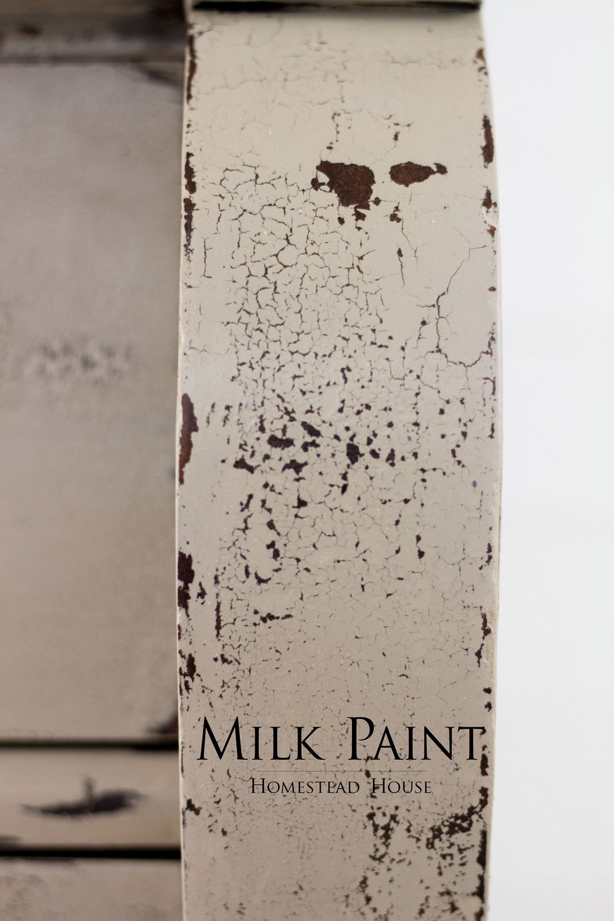 Cracked, peeling Algonquin Milk Paint by Homestead House with visible logo text.