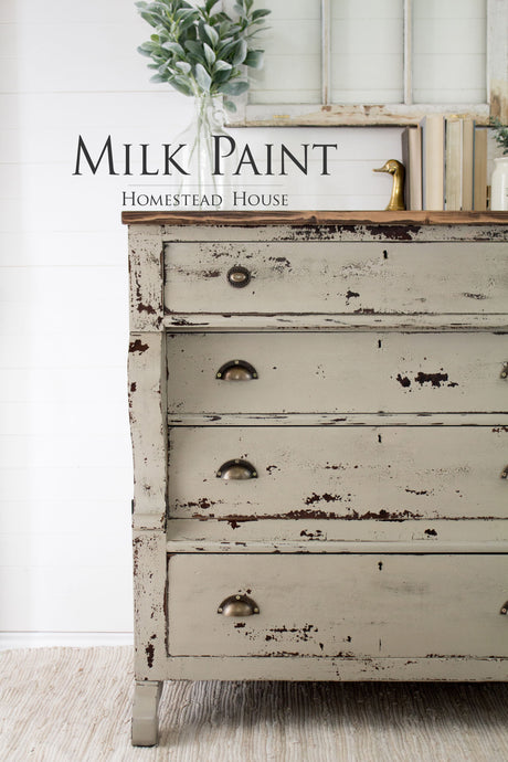 Distressed 3-drawer dresser painted Algonquin Milk Paint by Homestead House with decor on top.