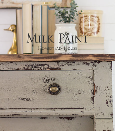 Dresser painted with Algonquin Milk Paint, brass knob, books, ceramic jar, and brass duck accent on top.