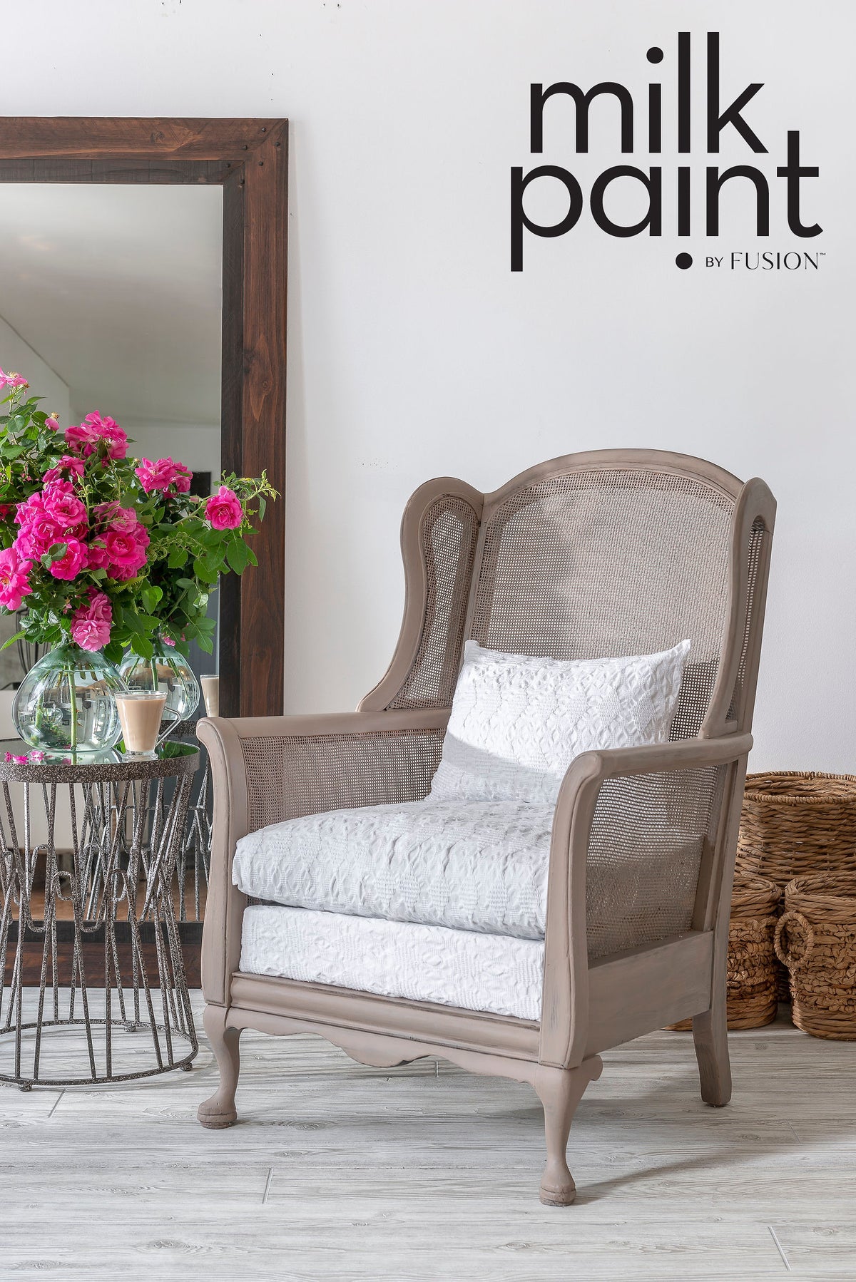 Beige armchair with white cushion beside table, pink flowers, and baskets; Fusion Mineral Paint Almond Latte above.