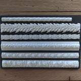 Six white Notions Amazing Casting Resin trim borders arranged on a plain black background.