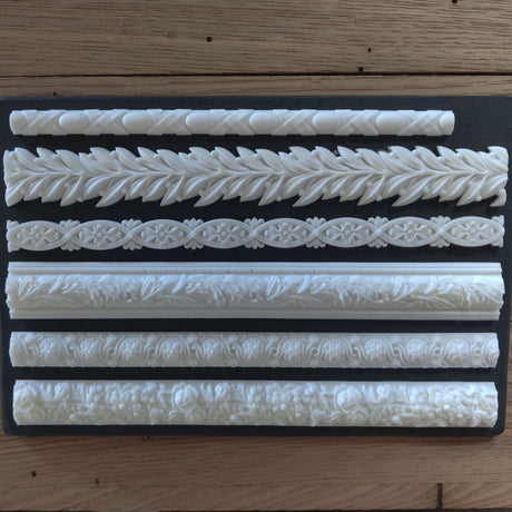 Six white Notions Amazing Casting Resin trim borders arranged on a plain black background.