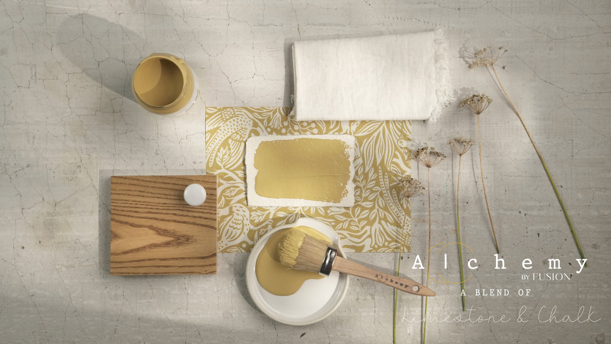 Paintbrush, Fusion Mineral Paint jar, wood block, cloth, dried flowers, and Alchemy by Fusion Digital Downloads text.