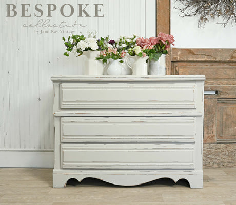 White distressed dresser in Antique Ironstone Old Fashioned Milk Paint, accented with vases.