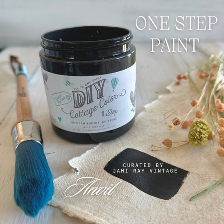 Open Anvil DIY Cottage Color by DIY Paint Co. with a blue brush, dried flowers, and painted fabric swatch nearby.