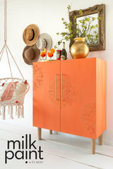 Orange cabinet with floral designs, painted in Fusion Mineral Paint Aperol Spritz.
