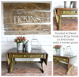 Green wooden drop-leaf table painted with Old Fashioned Milk Paint in Artichoke, shown with metal baskets and flowers.