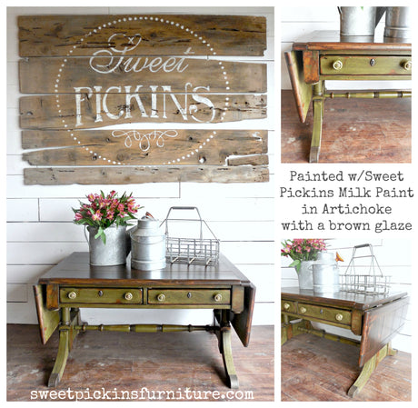 Green wooden drop-leaf table painted with Old Fashioned Milk Paint in Artichoke, shown with metal baskets and flowers.