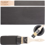 Ash by Fusion Mineral Paint in dark charcoal grey shown on stirrer, surface, brush, and can.