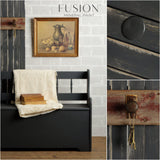 Black bench painted in Ash by Fusion Mineral Paint, dark charcoal grey, cream knit blanket draped over seat.