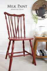 Red chair painted with Homestead House Barn Red Milk Paint positioned beside a table.