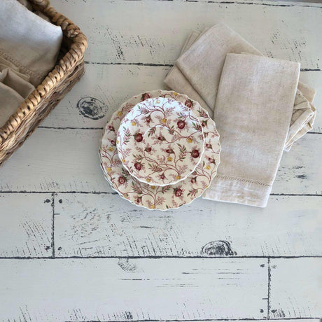 Two patterned plates, beige napkins, and a basket on a table stamped with Barnwood Planks by I.O.D.