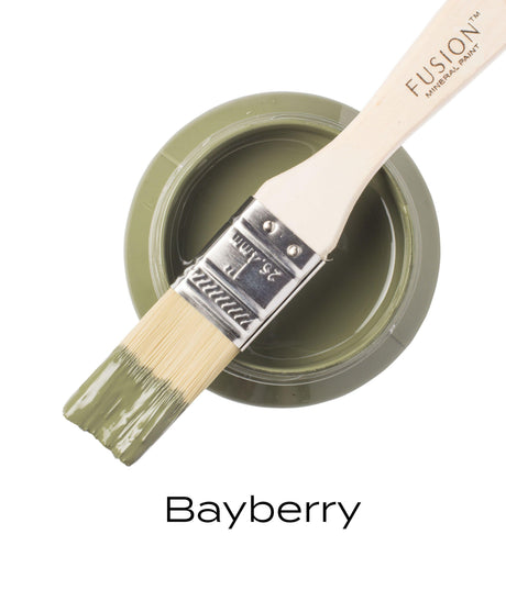 Open jar of Bayberry Fusion Mineral Paint, olive green acrylic, with paintbrush resting on the rim.