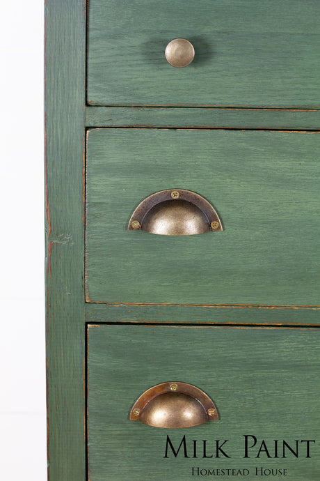 Green wooden dresser with three drawers, brass handles, painted in Homestead House Bayberry Milk Paint.