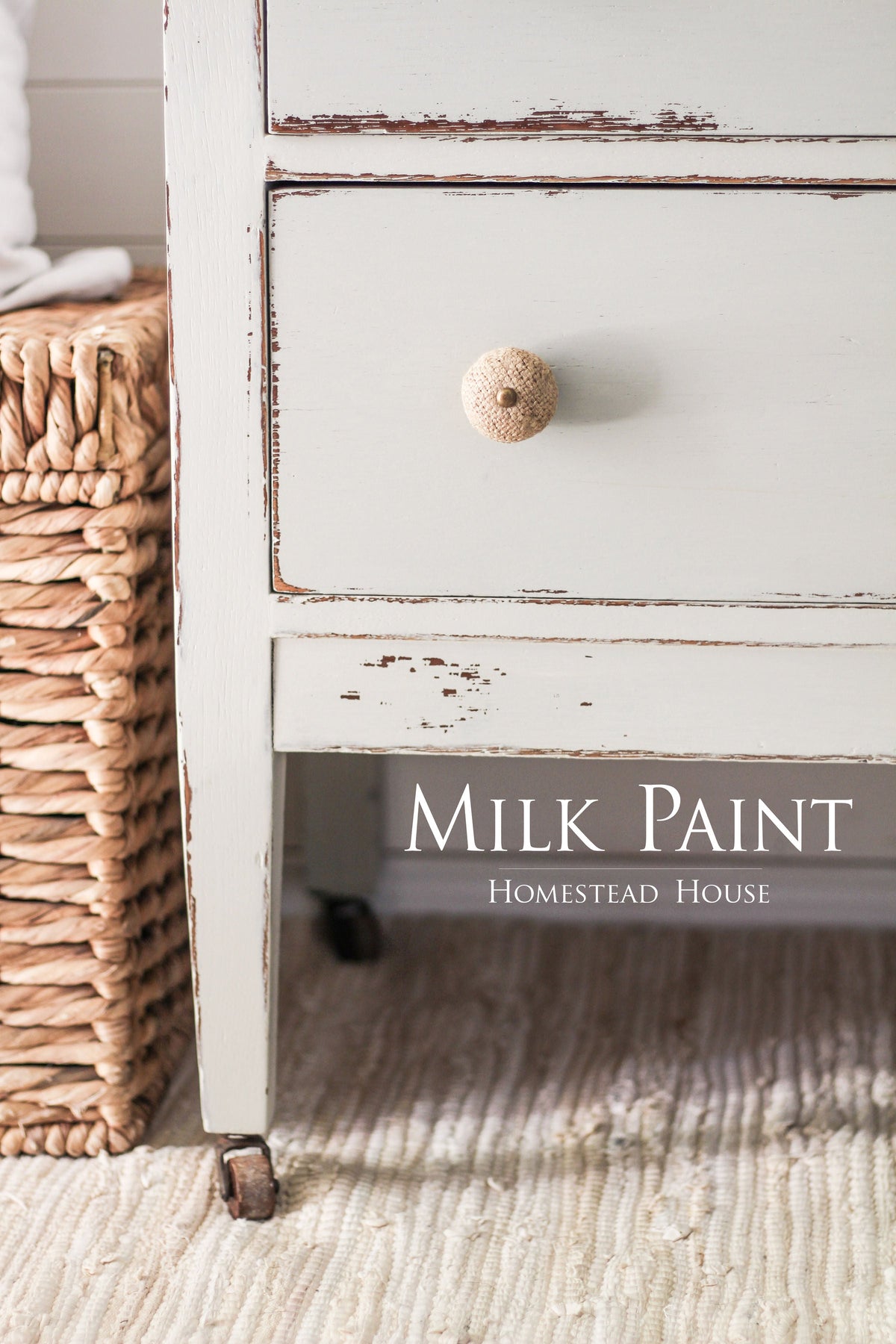 Distressed white drawer with woven knob, next to a wicker basket; Homestead House Bedford Milk Paint shown.