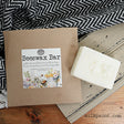 Old Fashioned Milk Paint Beeswax Bar with box on wood surface, next to a chevron cloth.