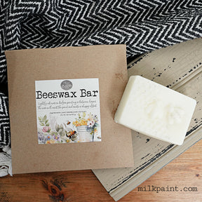 Old Fashioned Milk Paint Beeswax Bar with box on wood surface, next to a chevron cloth.