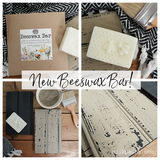 Old Fashioned Milk Paint Beeswax Bar with painting tools, wood panels, and a “New!” sign on a table.