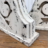 Pair of distressed white corbels with black chipping, finished in Old Fashioned Milk Paint and Beeswax Bar.