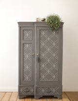 Gray vintage wardrobe with patterned doors; a plant and I.O.D. Bella Stamp (Retired) displayed on top.