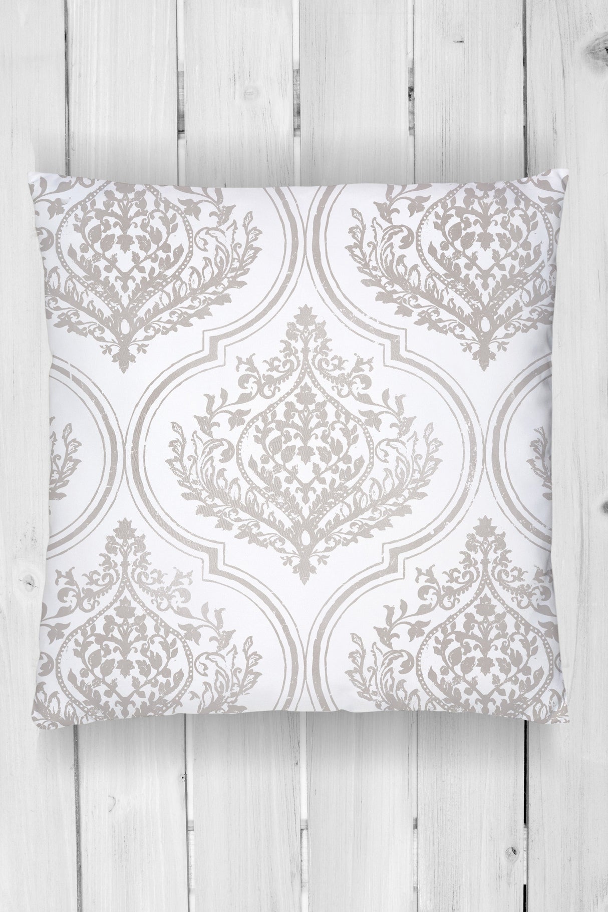 Square pillow with light gray ornate Bella Stamp (Retired) by I.O.D. pattern on white wood planks.