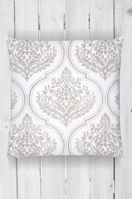 Square pillow with light gray ornate Bella Stamp (Retired) by I.O.D. pattern on white wood planks.
