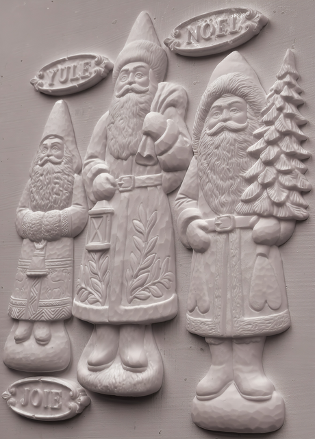 Three white Santas by I.O.D. Belsnickel Mould, each holding a YULE, NOEL, or JOIE sign; 2026 limited release.