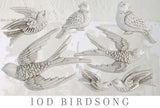 Seven white birds created with the I.O.D. Birdsong Mould displayed on a textured gray surface.